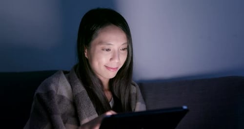Woman use of tablet computer at night