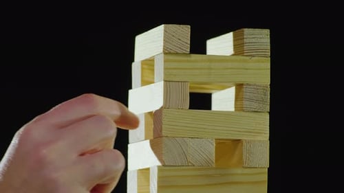 La main tire un bloc de bois de la tour. Je joue à Djanga. Concept de jeux
de société