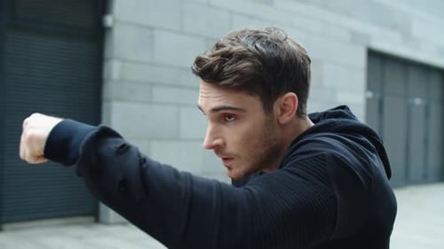 Focused Man Practicing Boxing Punching Outdoors