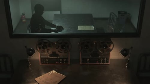 Interrogation room behind one-way mirror glass. Police detective suspect.