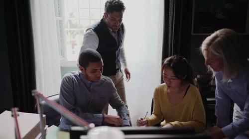 Group of people looking at blueprint in the office