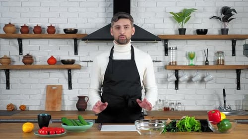 Mannkoch in Schürze hört zu, lehrt Hausfrau zeigt Zutaten zum Kochen von Salat