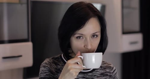 Portrait of Pretty Young Brunette Woman Smiling and Drinking Coffee From Cup