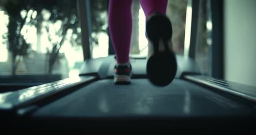 Legs of a Male Athlete on a Treadmill