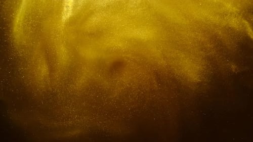Sable doré ou poussière créant des formations nuageuses abstraites