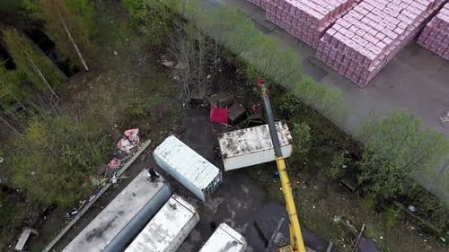 Crane Lifting Shipping Container onto Truck from Above