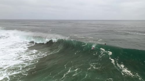 surfer riding a big wave in a lonely surf spot, feeling freedom surrounded in nature