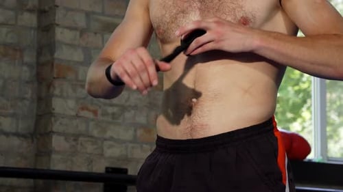 Shirtless Athlete Wraps Hands with Tape