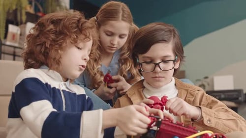 Caucasian School Kids Building Robot Together