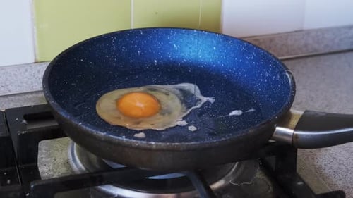 Frühstück zu Hause. Spiegeleier werden in einer Pfanne in der Küche zu Hause gekocht