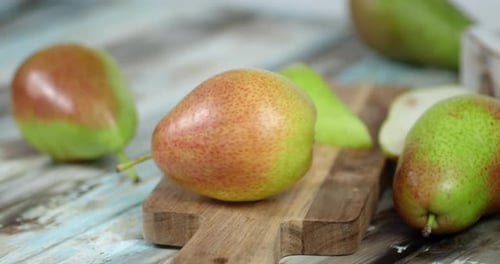 Pear Is Rotating on a Wooden Cutting Board.