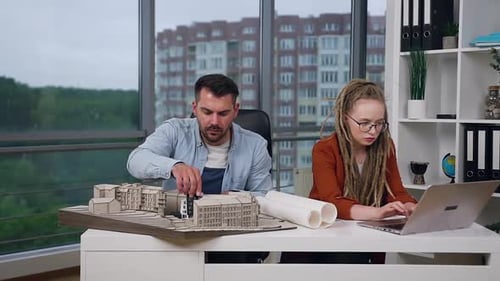 Architects Collaborate on Building Model in Office