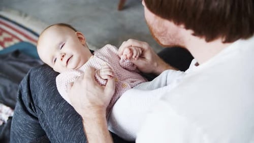 Father Holds Infant Child in Lap Indoors