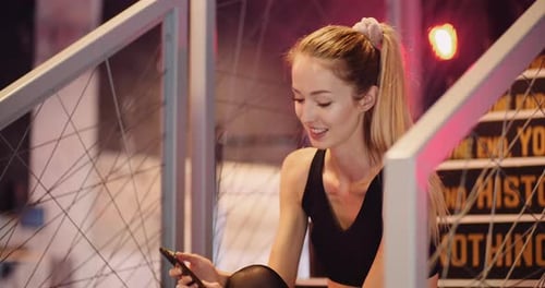 Fit Young Woman Using Smartphone In Gym