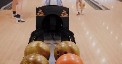 Nahaufnahme von Bällen, die während des Bowlingspiels zurückkehren