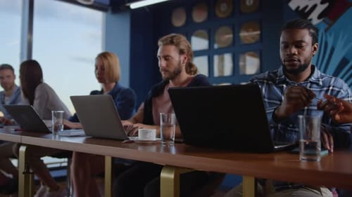Team Working Together on Laptops in Office