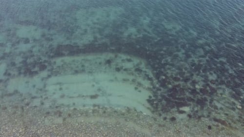 Transparent sea water. Layered rocky bottom of sedimentary rocks underwater. Geology of the seabed