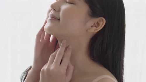 Young Woman Gently Touching Her Face Indoors