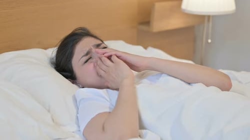 Jeune femme indienne pleurant en dormant dans son lit