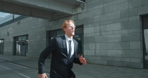 Young Businessman Runs Down City Street