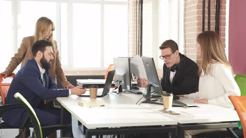 Group of a Young Business People Brainstorming and Discussing Business Plan in Office