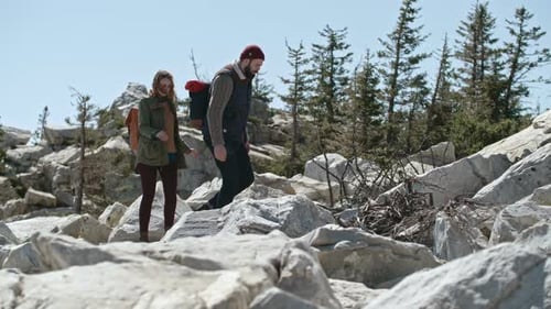 Couple Hiking Up Rocky Mountain Trail
