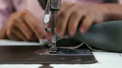 Mann arbeitet an einer Nähmaschine.
