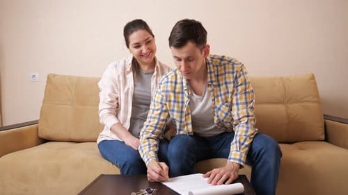 Couple Signing Paperwork and Celebrating With Keys
