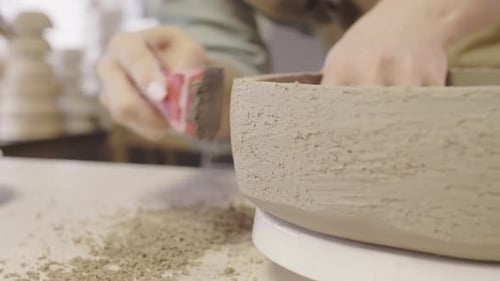 Woman Smoothing Handmade Ceramic Bowl in Studio
