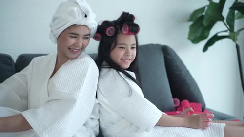 Woman and Child Wearing Robes Playing Together