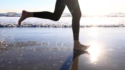 Slow motion shot of an Asian woman jogging on the beach