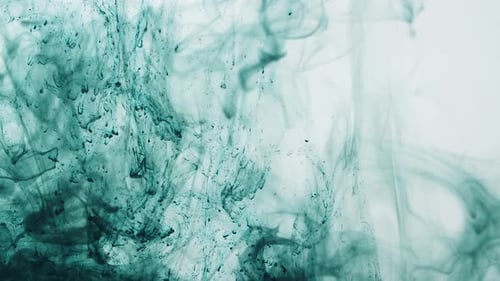 Grüne Tinte zerstreut sich in Wasser auf weißem Hintergrund