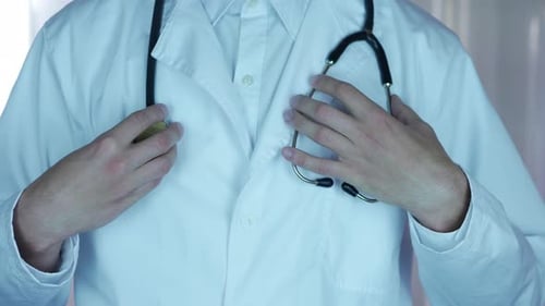 Doctor Adjusting White Coat in Hospital Close Up