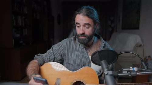 Man Plays Guitar and Records Music at Home