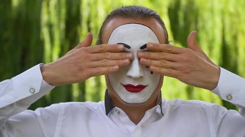 Mime on the Park zeigt Pantomime. Mime schließt ihre Augen mit den Händen