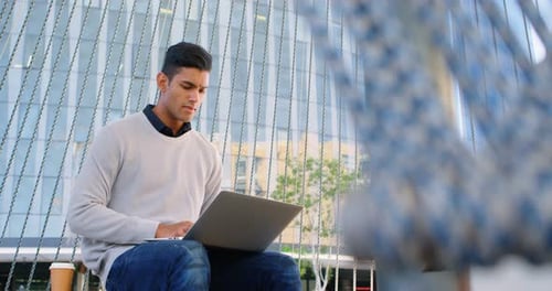 Male Commuter Using Laptop in Office Premises