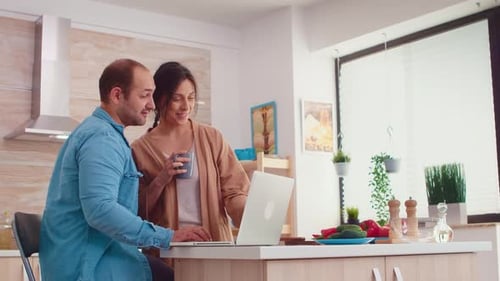 Couple Using Laptop in Bright Modern Kitchen