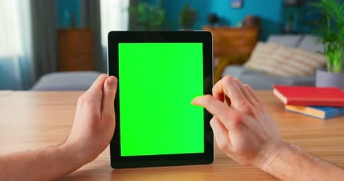 Closeup of Man Using Hand Gestures on Green Mockup Screen Digital Tablet Computer in Landscape