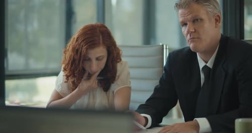 Medium shot of two people making notes during a business meeting in the office room. Slow motion.