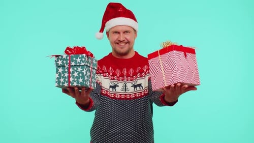 Man Holding Christmas Gifts and Wearing Santa Hat
