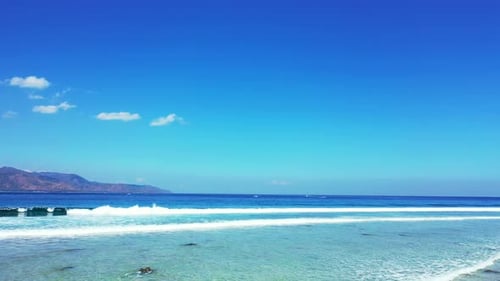 Daytime fly over tourism shot of a paradise sunny white sand beach and aqua turquoise water backgrou