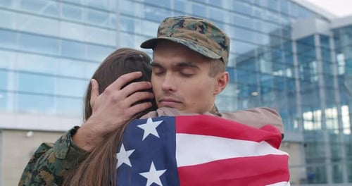 Soldier Returns Home, Embracing Loved One with Flag