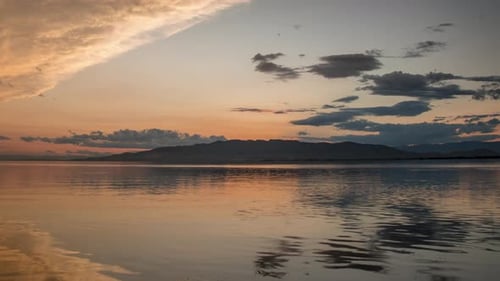 Tranquil Lake at Sunset with Mountain Backdrop