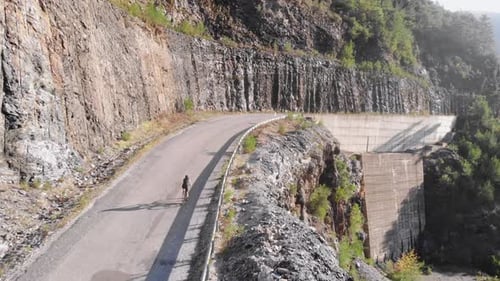Cyclist on road bicycle riding on road in mountains.