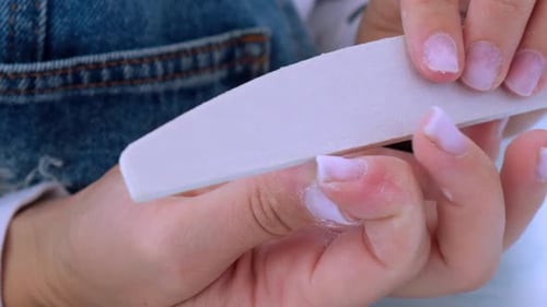 Woman Filing Nails in Preparation for Manicure