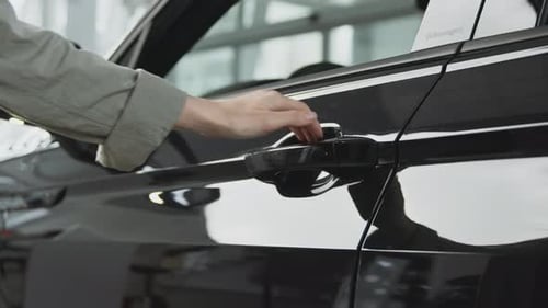 Unrecognizable Woman Opening Door of New Car Choosing Vehicle at Dealership Showroom Tracking Shot