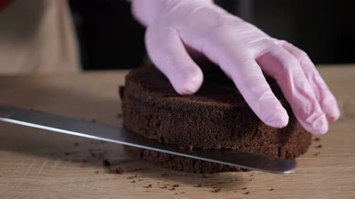 Gloved Hand Cuts Chocolate Cake Layer
