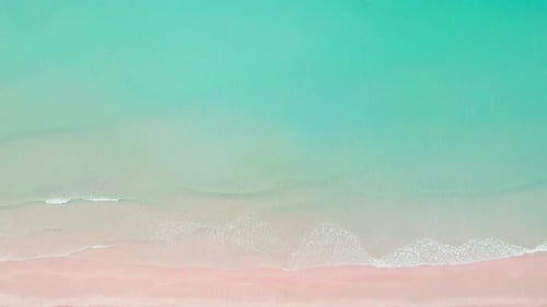4K Aerial view top view of drone, blue sea waves and beautiful pink sand beach.