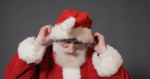 Man Puts on Santa Claus Hat
