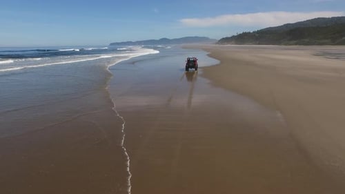 Aerial shot of 4x4 off road vehicle driving on beach